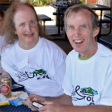John posing for a picture with another person at an event