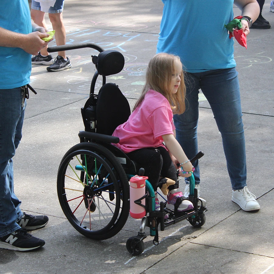 A young girl in wheel chair playing a tossing ball game